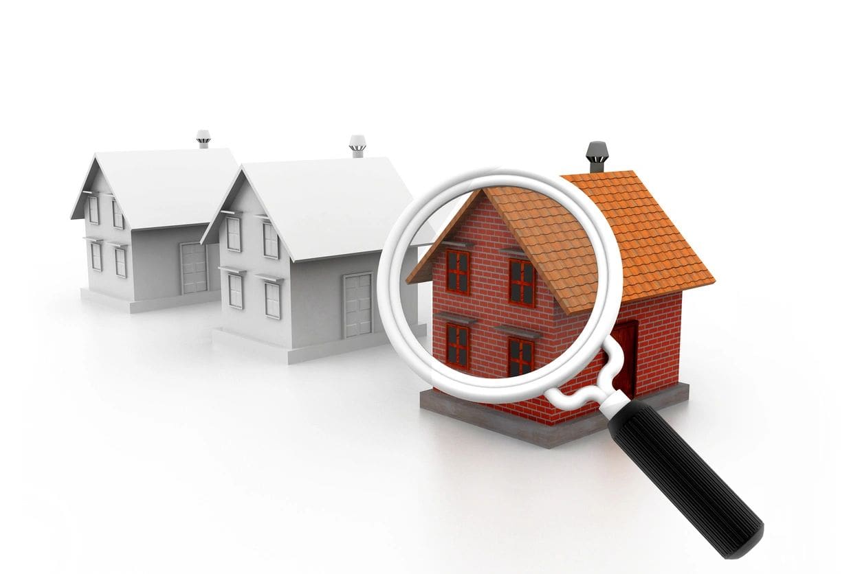 A magnifying glass is over a model of houses.